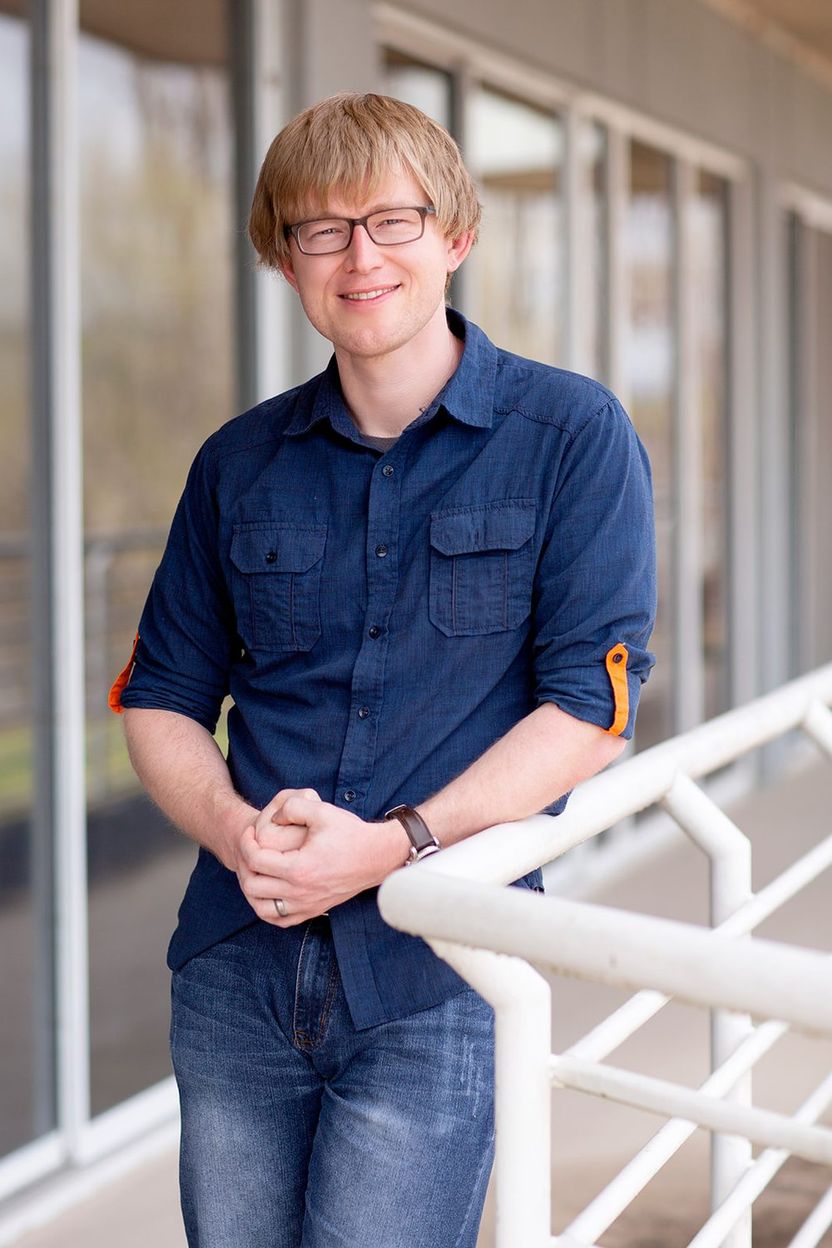 Douglas Hutchings leaning on a white railing, smiling
