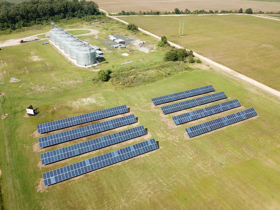 Aerial view of a Delta Solar array beside grain bins on an Arkansas farm